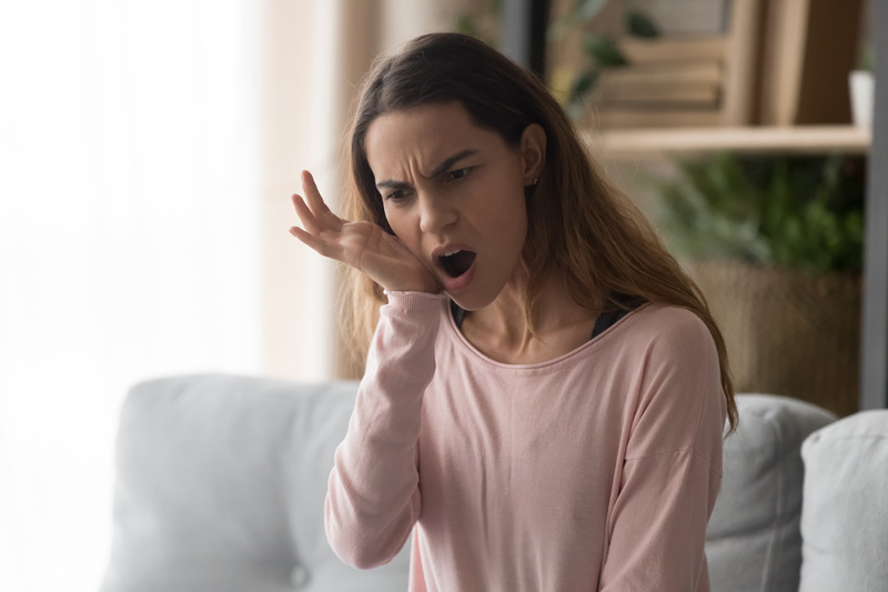 Patient holding their cheek due to a TMJ disorder